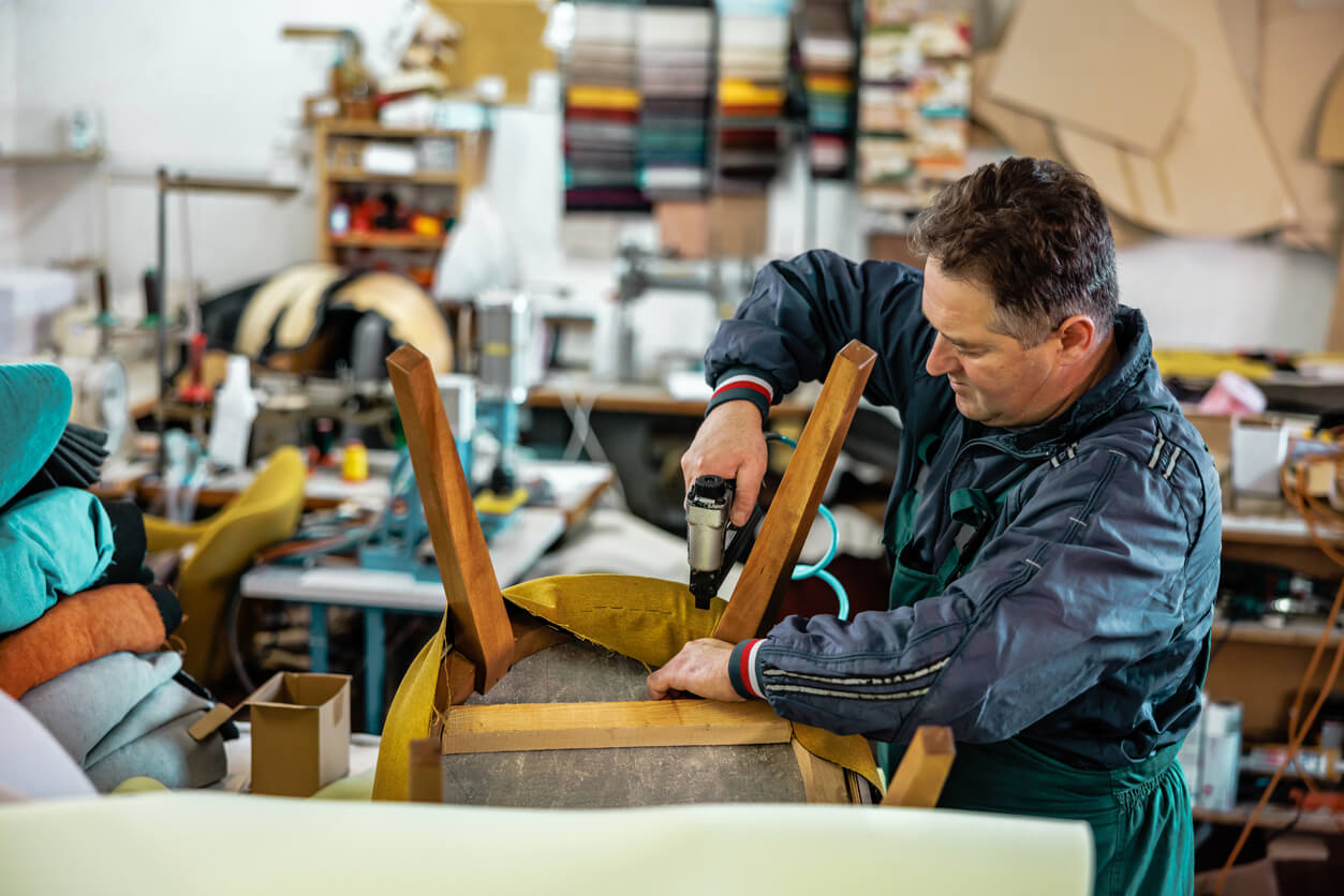 Man bekleed een stoel met textiel.